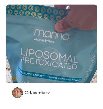 A manna customer holding up a bottle of Liposomal Pretoxicated 3